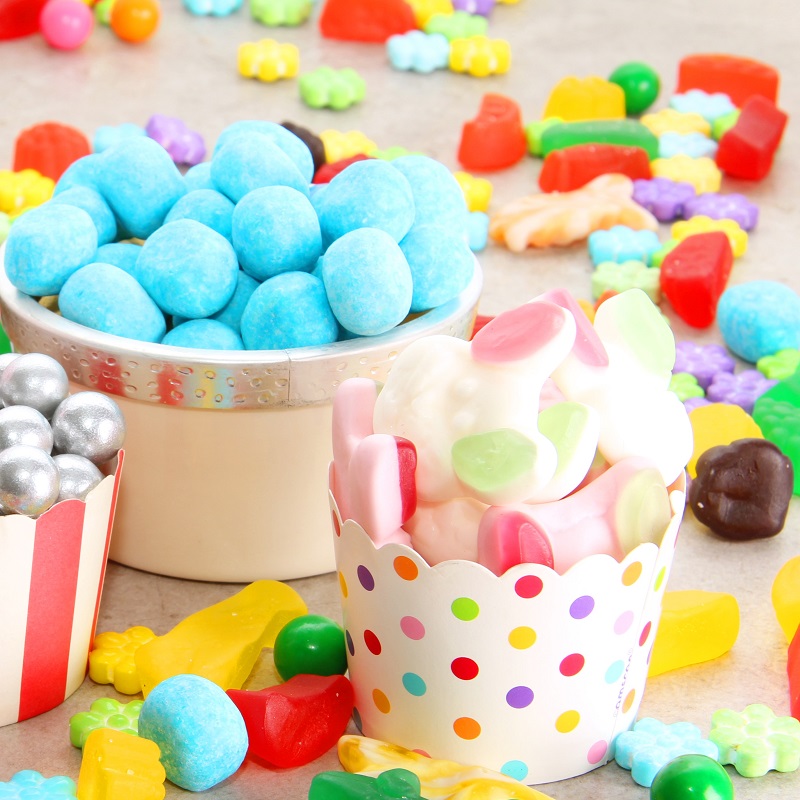 Assorted variety of sweet sugar candies includes bonbons, gummy bears, gum balls and sugar fruit slices. Assorted variety of sweet sugar candies includes bonbons, gummy bears, gum balls and sugar fruit slices.