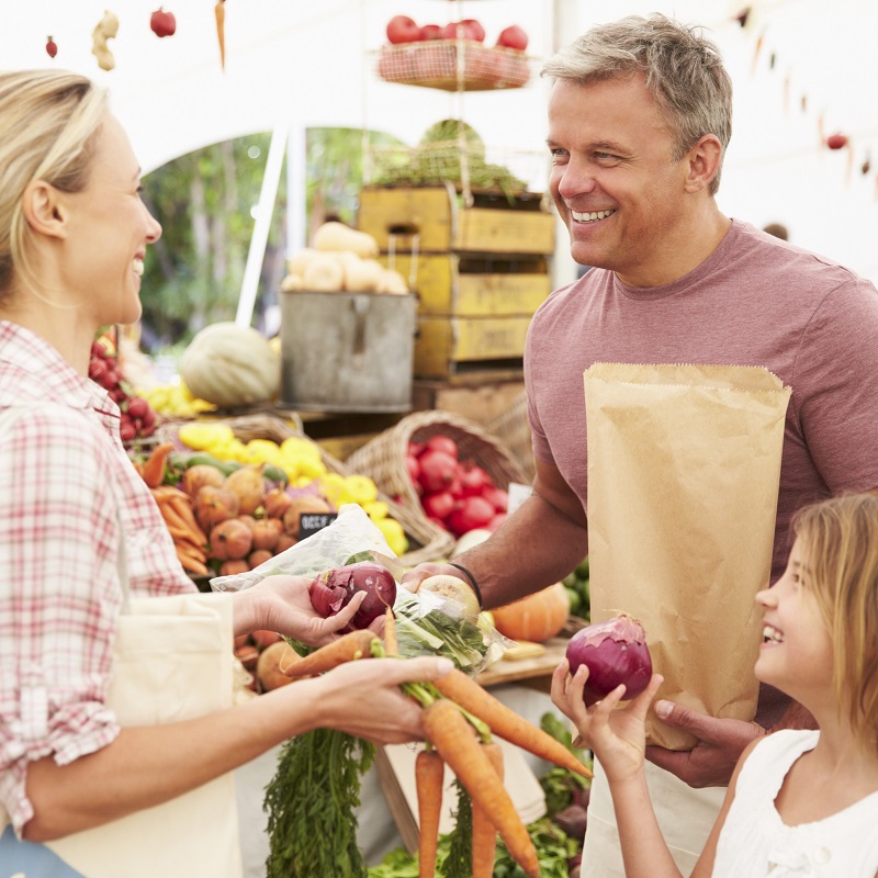 a family buying fruits and vegetables. a family buying fruits and vegetables.