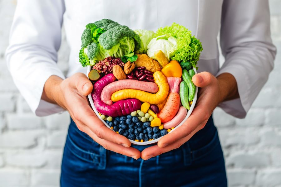 man holds a bowl of fibrous veggies, nuts and fruits over his belly man holds a bowl of fibrous veggies, nuts and fruits over his belly