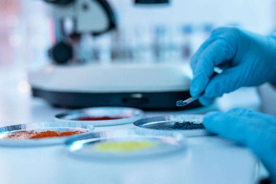 A scientist examines nutraceutical ingredients on a petri dish in a lab.