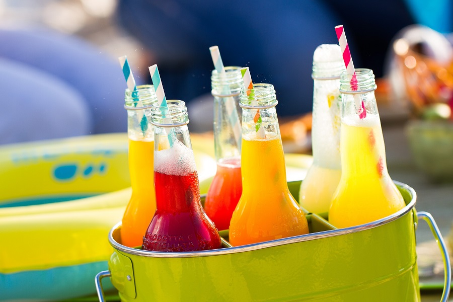 Bottles of lemonade standing in a colorful green bucket