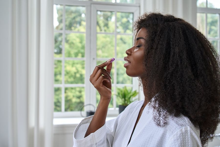A beautiful women prepares to take a supplement in pill form.