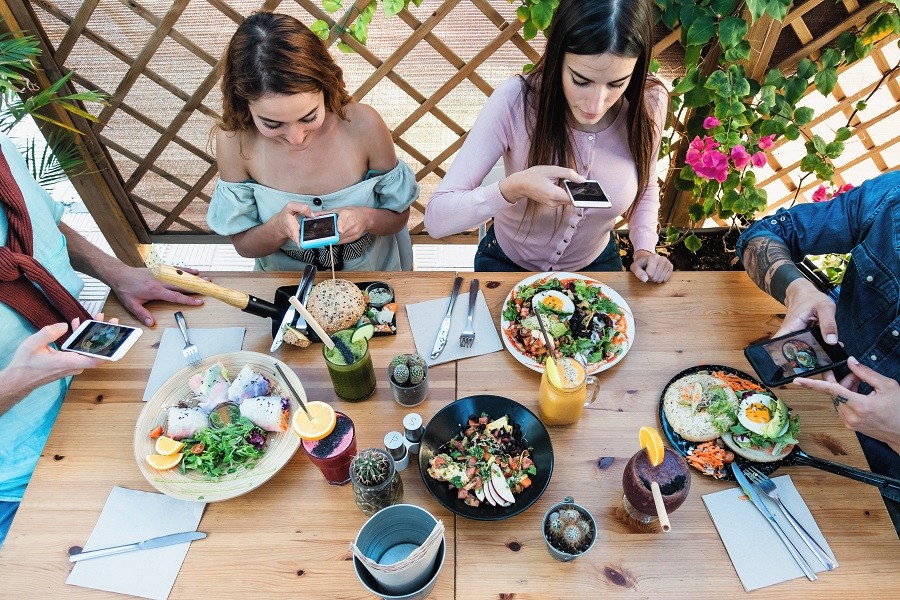 young people taking food pictures for social media