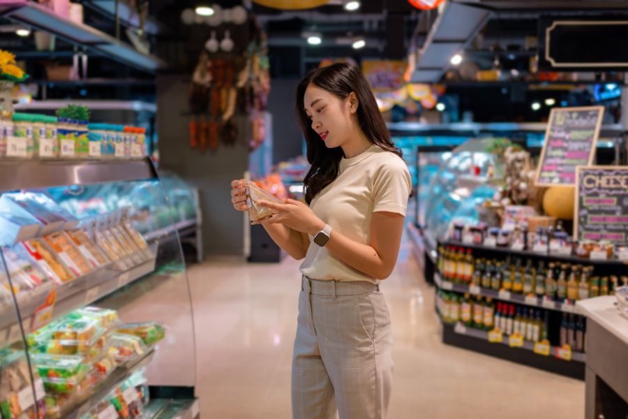 woman looking at QR code on product in supermarket