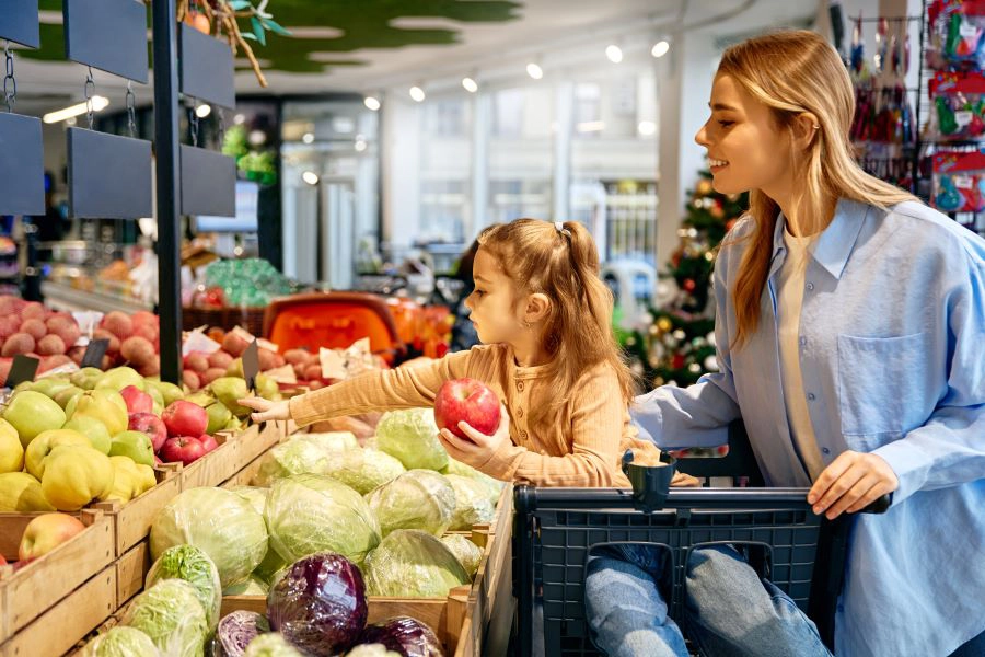 Little girl choosing apple with her mom while grocery shopping together Little girl choosing apple with her mom while grocery shopping together