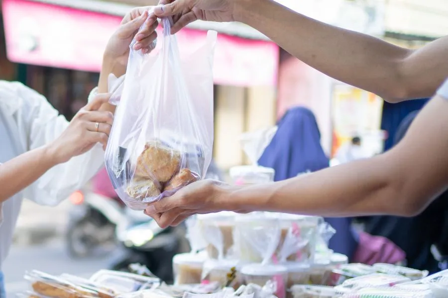 A person handing a bag of food to another person