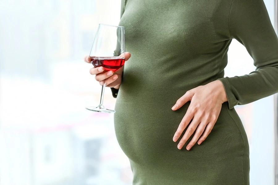 Pregnant woman drinking wine