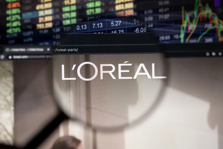 A Loreal website in front of the stock market page. A Loreal website in front of the stock market page.