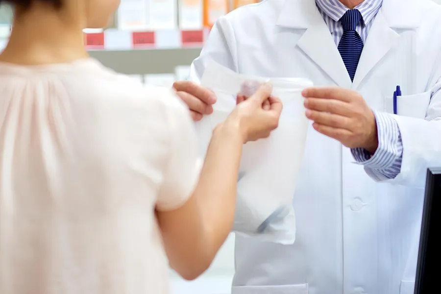A person receives a bag from a person in a white coat A person receives a bag from a person in a white coat