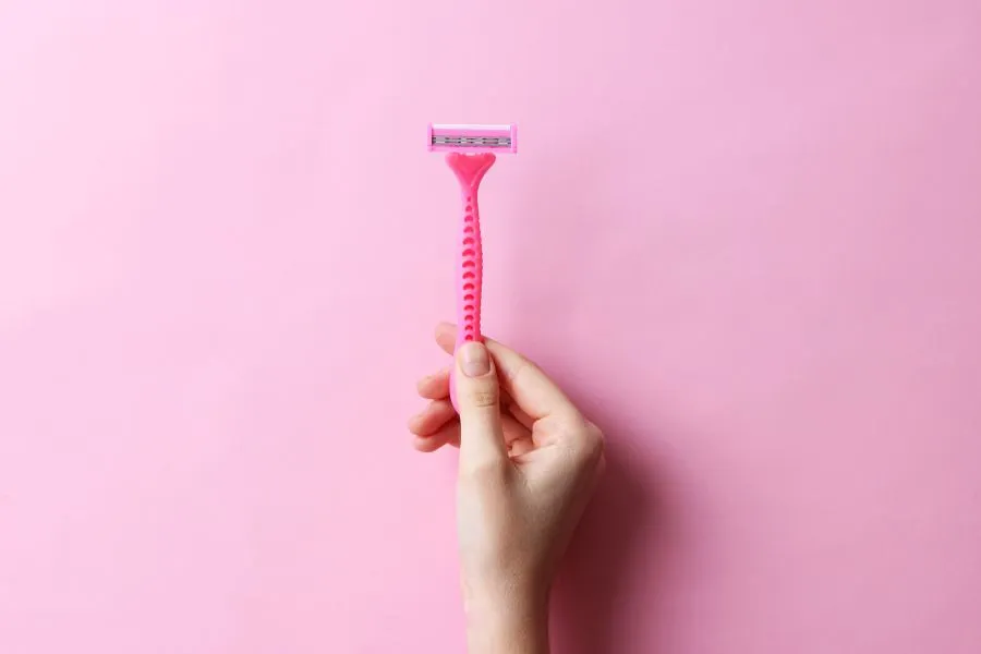 woman holding pink razor woman holding pink razor