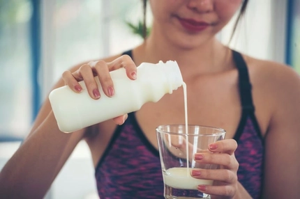 Image Woman pouring yogurt in a glass