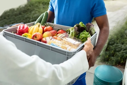 A person holding a PP corrugated box of vegetables