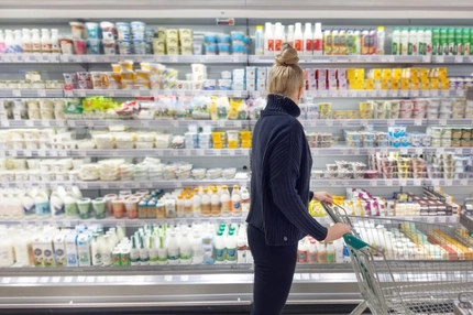 woman in supermarket choosing dairy products