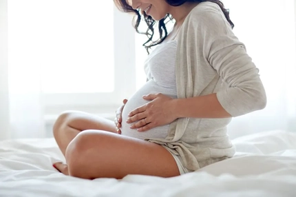 pregnant woman sitting on bed