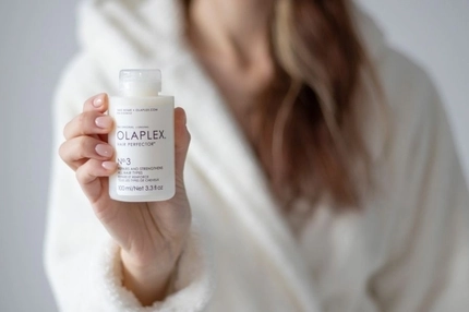 Image A hand holding a Olaplex hair care product.
