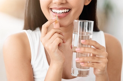 Close Up Of Happy Smiling Asian Woman Taking Supplement Pill And Holding Glass Of Fresh Water
