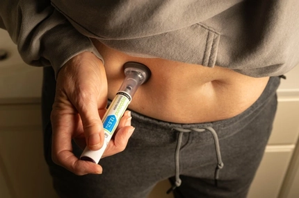 Person injecting weight loss medication into their stomach.