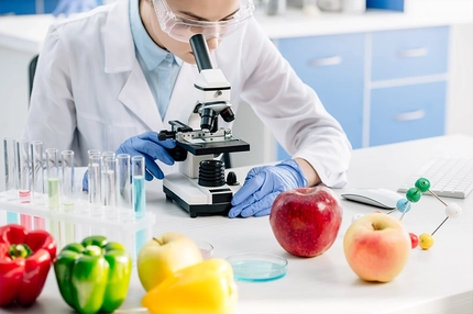 molecular nutritionist using microscope and sitting at table
