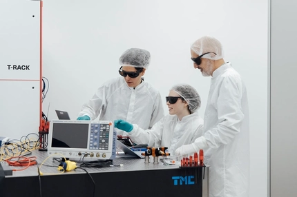 three scientists working on a computing device
