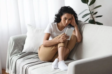 A woman on her phone looking stressed.