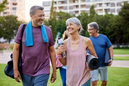Image 4 middle aged people carrying mats and waterbottle after workout