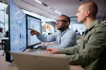 Image Two men check compliance data