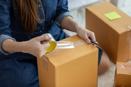 Image A person packing a box.
