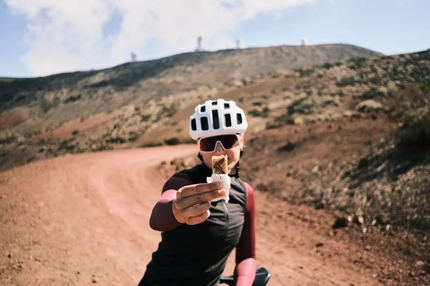Image Cyclist eating protein bar in the mountains