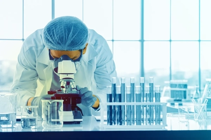 Image A scientist looking into a microscope.