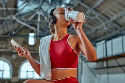 woman drinking protein shake in the gym