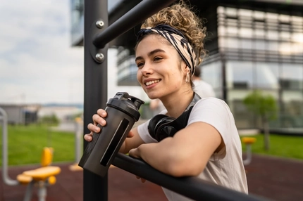 Image Young woman exercising and drinking high-protein beverage.
