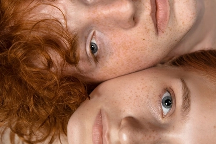 Image two people with red hair and freckles looking into camera - close up of faces