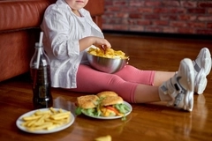 Child eating chips and surrounded by junk food. Child eating chips and surrounded by junk food.