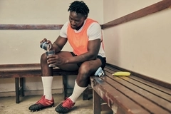 a young athlete pouring protein powder in a shaker
