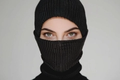 A woman wearing a balaclava but you can only see her eyes.