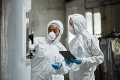 Two employees checking fermentation equipment