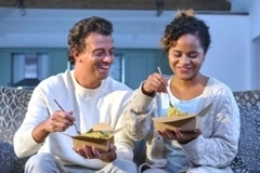 People on sofa eating takeaway food. People on sofa eating takeaway food.