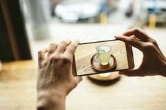 Person using their phone to take a picture of tea. Person using their phone to take a picture of tea.