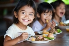 Smiling children sit at a table sharing a nutritious breakfast