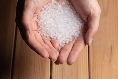 two hands holding white beeds