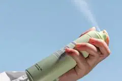 A spray deodorant being put into the air.