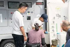 A group of people standing next to a machine