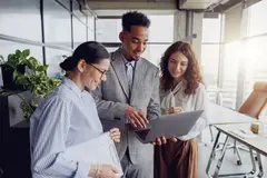 Researchers collaborating behind a computer