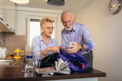 older couple looking at recycling waste