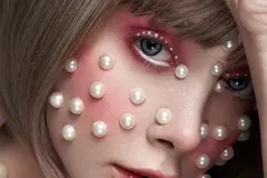 A woman with pearl stickers on her face.