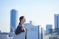 happy japanese woman with city buildings in background