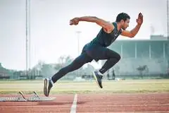 A man takes of for a sprint in an olympic style running competition.