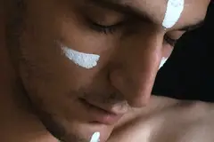 A man with stripes of white on his face.