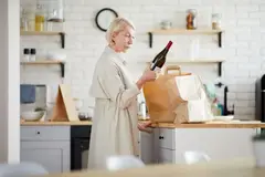 woman looking at wine bottle
