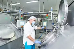 dairy worker with mask working on fermentation tank